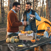 Campers using 12Pcs Camping Cookware Set while enjoying a meal outdoors. Ideal for group camping and outdoor adventures.