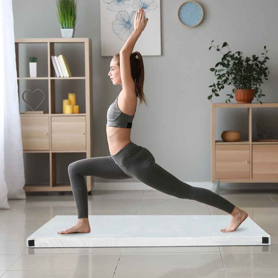 Woman practicing yoga on a white mat in a home setting