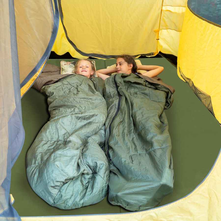 Two people lying in green sleeping bags inside a yellow tent.
