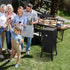 Family gathered around a barbecue grill in a backyard setting