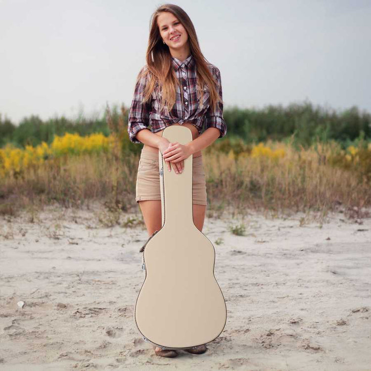 Woman holding a guitar case in a natural setting with yellow flowers and greenery.
