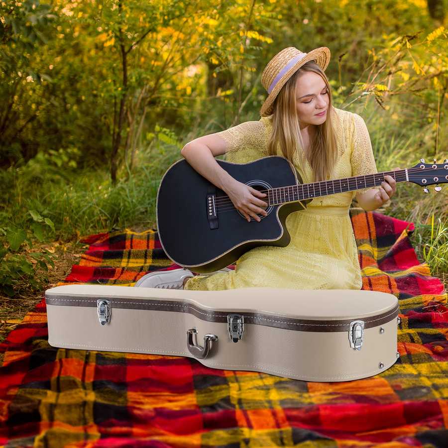 Woman playing guitar outdoors on a colorful blanket with trees in the background