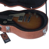 Electric guitar in an open brown case with a visible brand tag.
