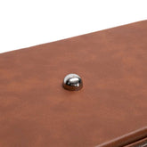 Close-up of a brown leather product with a metallic button on a white background