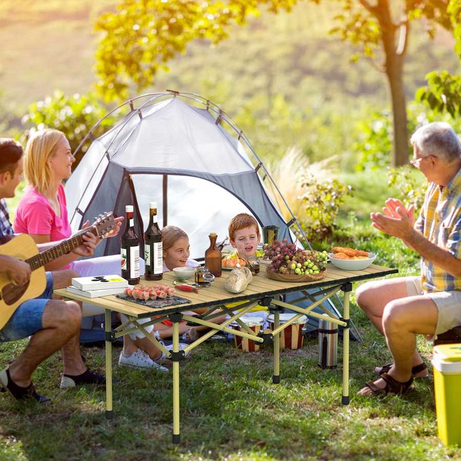 Family enjoying a picnic outdoors with a tent in the background