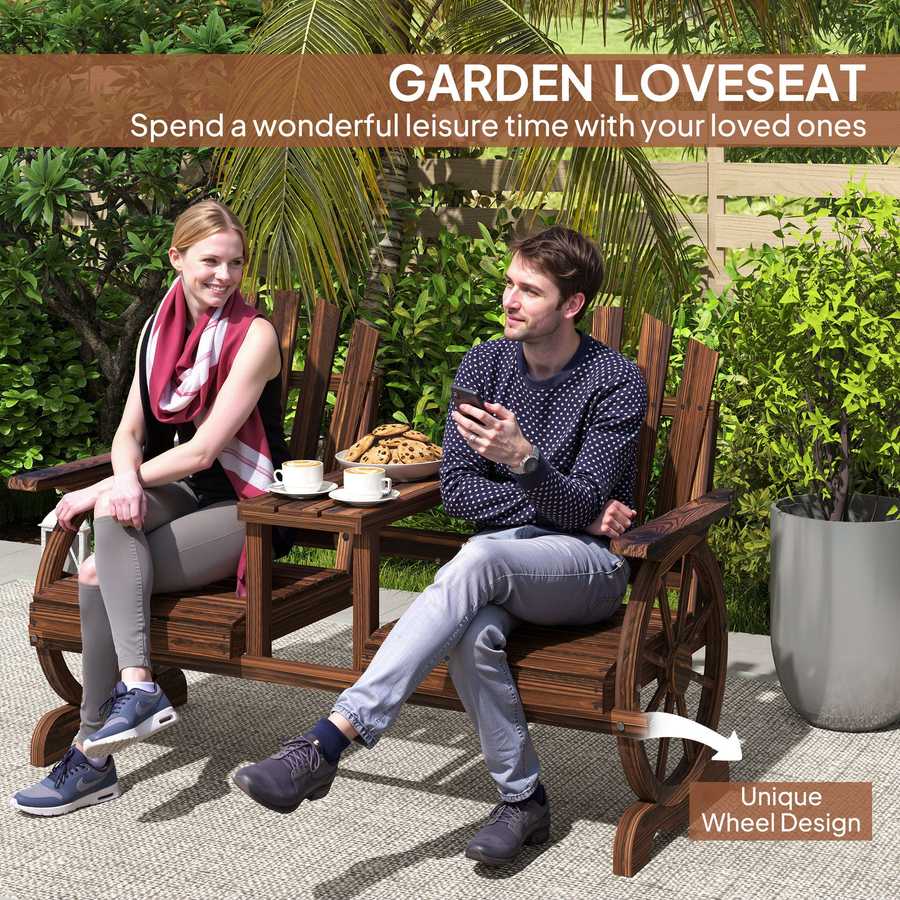 Two people sitting on a wooden garden loveseat with a table, surrounded by greenery.