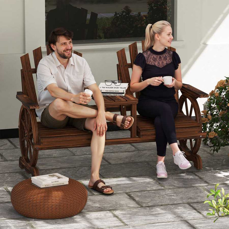 Two people sitting on a wooden bench outdoors, enjoying coffee.