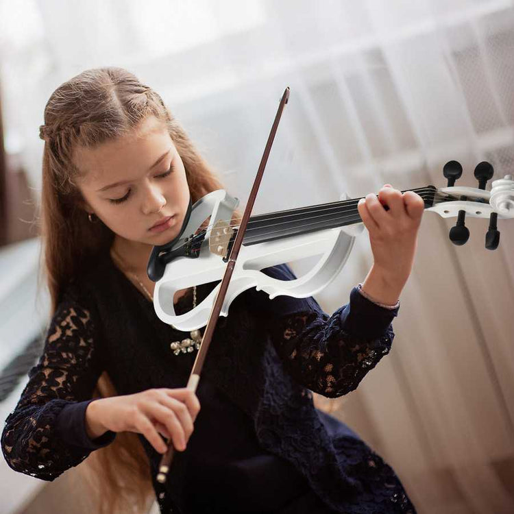 Young girl playing a white violin with a blurred background