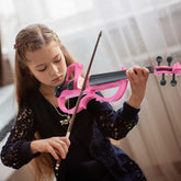 Young girl playing a pink violin with a blurred background
