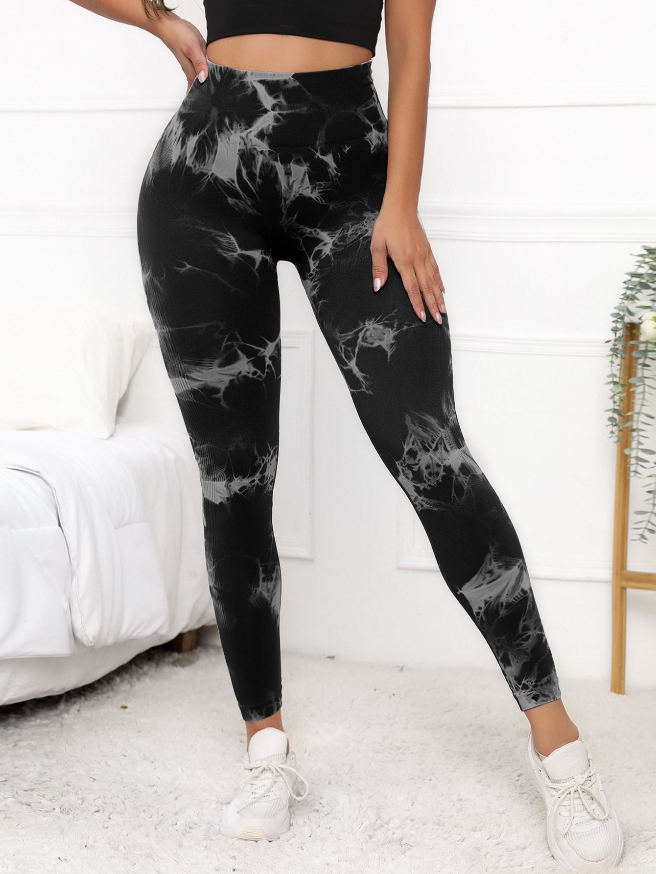 Women's compression fit scrunch leggings in black marble design, offering high waist support and shaping for fitness and yoga routines.