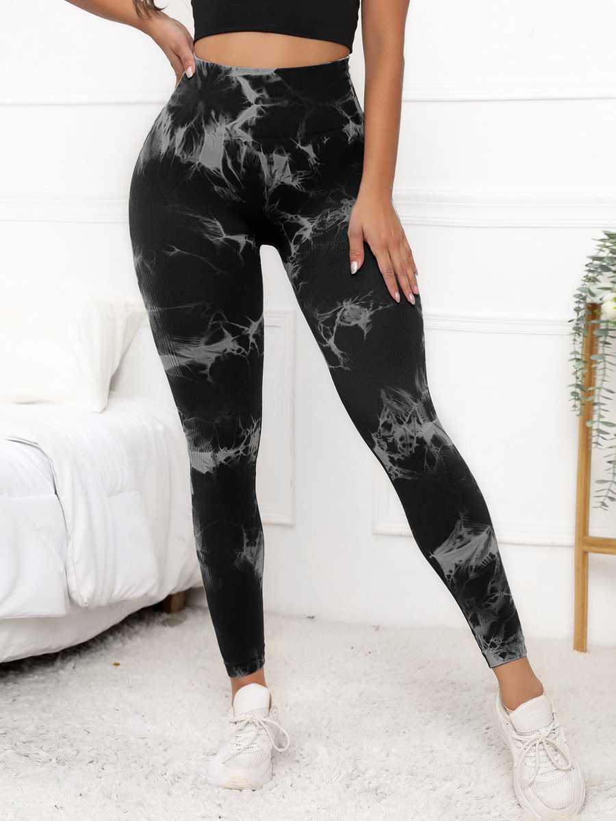 Women's compression fit scrunch leggings in black marble design, offering high waist support and shaping for fitness and yoga routines.