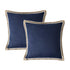 Two navy blue pillows with beige trim on a white background