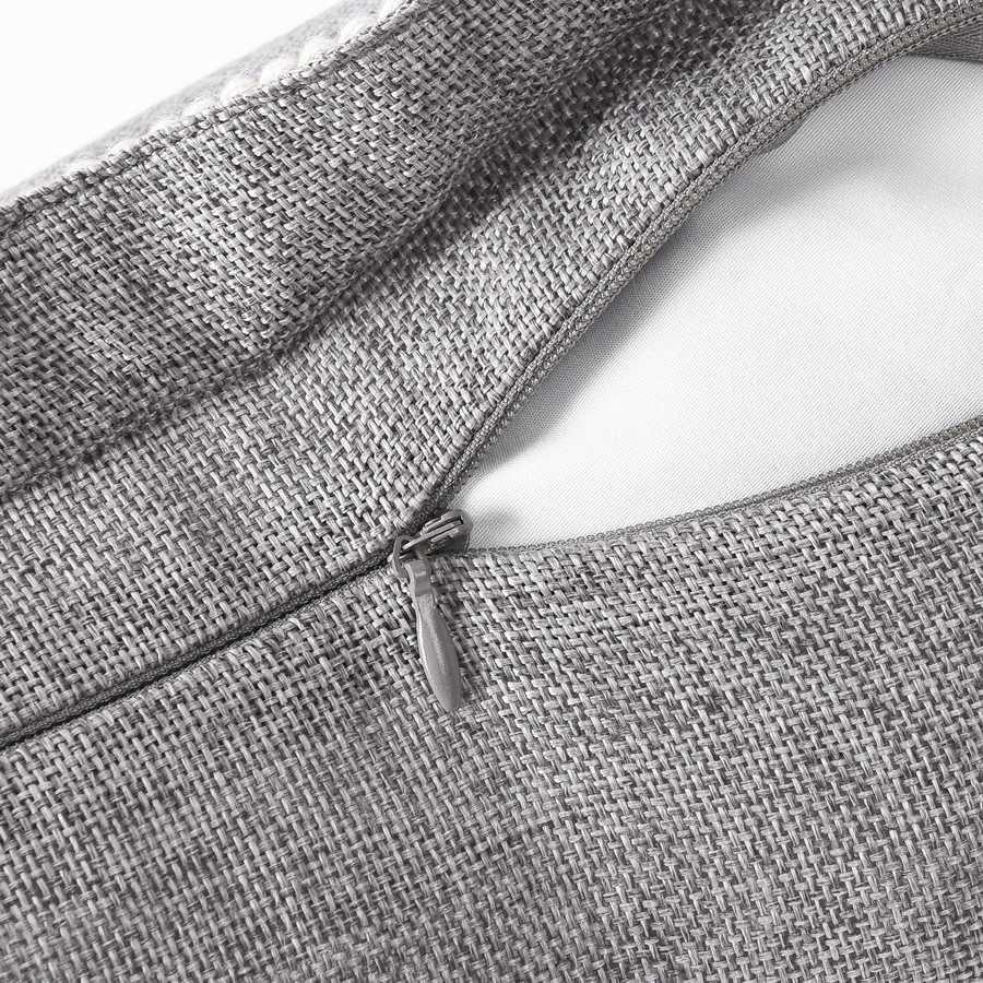 Close-up of a zipper on a textured gray fabric bag.