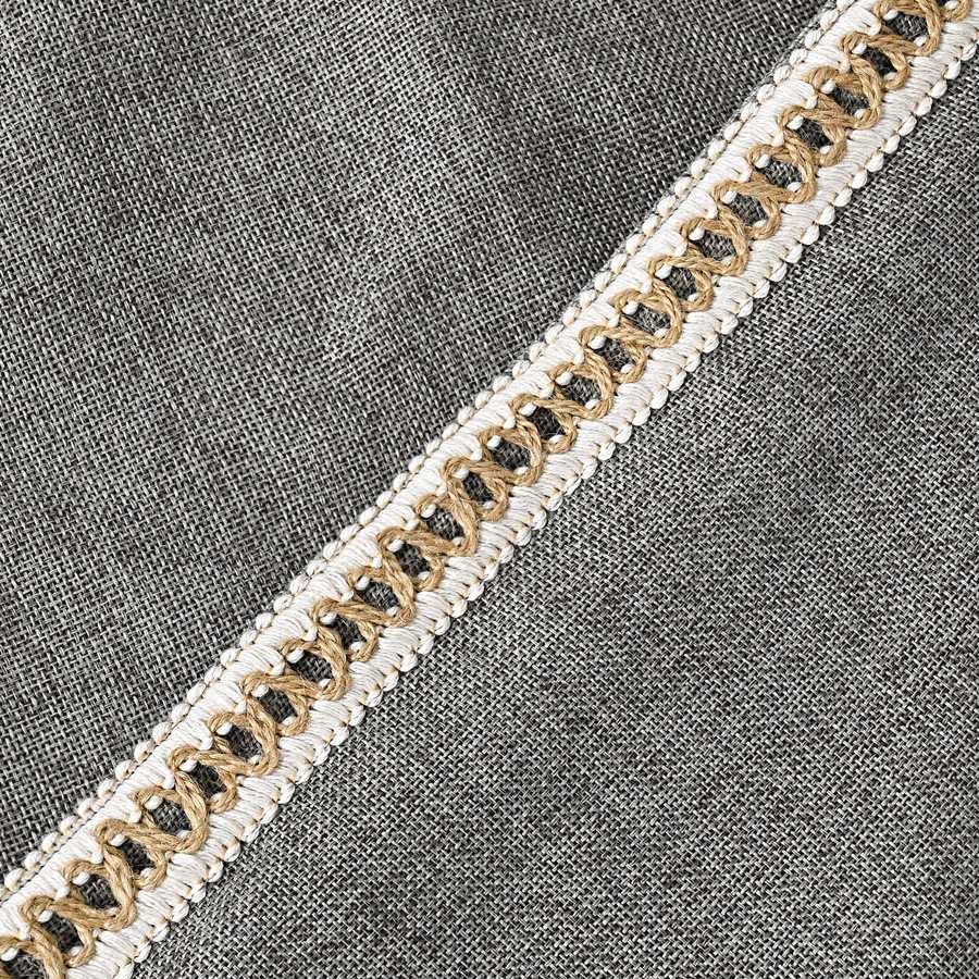 Decorative ribbon with gold and black pattern on a gray fabric background
