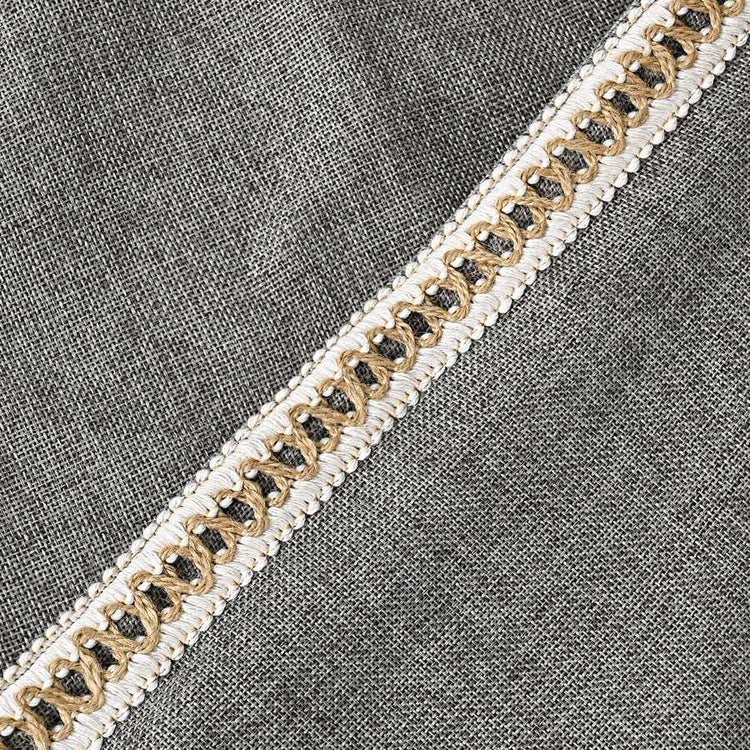 Decorative ribbon with gold and black pattern on a gray fabric background