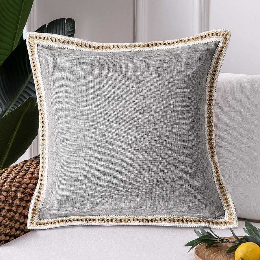 Gray pillow with decorative trim on a couch