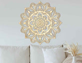 Decorative gold mandala wall art on a light gray wall above a sofa.