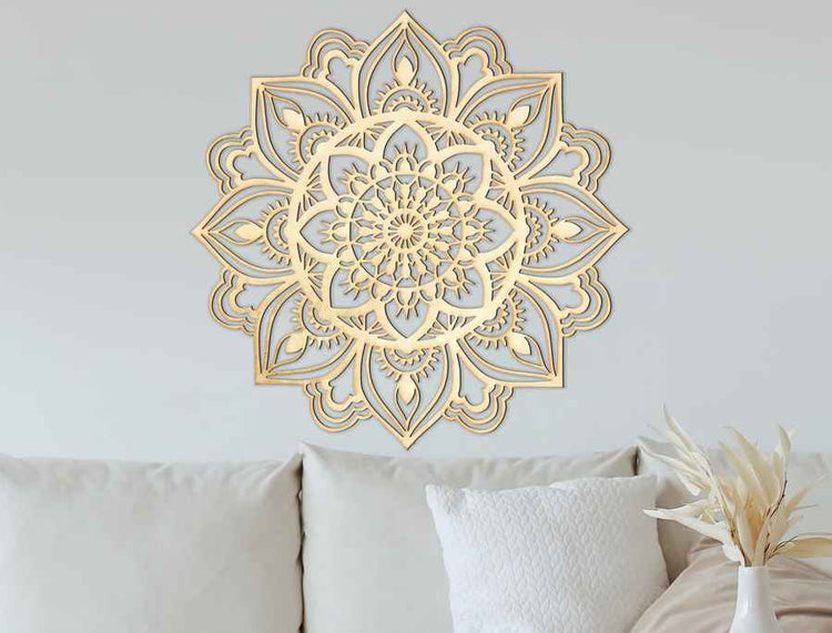 Decorative gold mandala wall art on a light gray wall above a sofa.