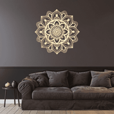 Decorative mandala wall sticker on a dark wall above a brown sofa.