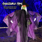 Adjustable witch Halloween decoration with a green face, white hair, black hat and robe, and purple translucent webbed arms, shown with text and arrows explaining arm adjustment.