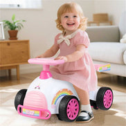 Toddler girl riding Kids Ride-On Car Toy with unicorn theme, promoting balance and coordination in a playful indoor setting.