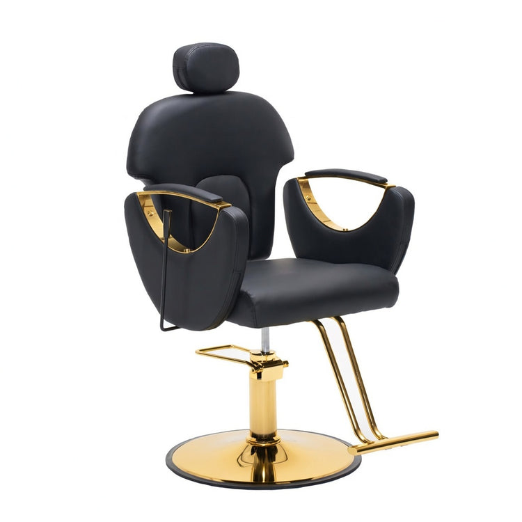 A modern barber chair with black faux leather upholstery and polished gold metal accents, including the base, footrest, and armrest trim, shown against a plain white background.