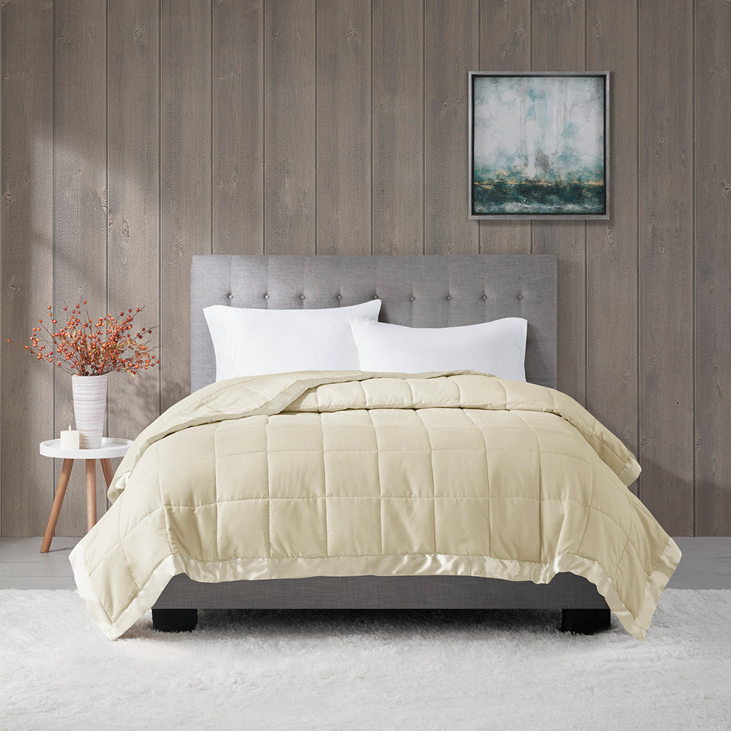 Cream Down Alternative Blanket Twin with satin trim displayed on a tufted bed, offering hypoallergenic warmth and elegant bedroom style.