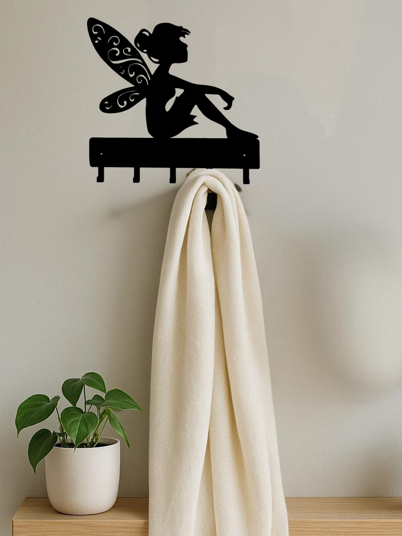 Fairy-themed fantasy wall hook key holder on a neutral wall, holding a white towel. Decorative and practical wall decor for home organization.