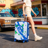 Person pulling a colorful suitcase with a vintage car and graffiti in the background