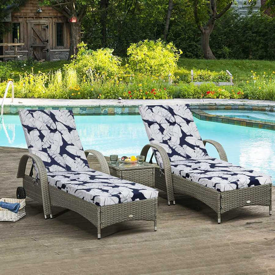 Two wicker lounge chairs with blue and white cushions by a poolside.