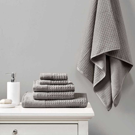 Cotton Jacquard Antimicrobial Bath Towels - 6 Piece Set in grey displayed on a white vanity with one towel hanging, ideal for modern bathrooms.