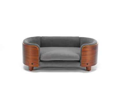 Front view of small Scandinavian Elevated Dog Bed featuring a curved solid wood frame and plush grey velvet cushion for luxury pet lounging.