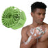 Man using a green scrubber on his skin with a close-up of the scrubber on a white background.