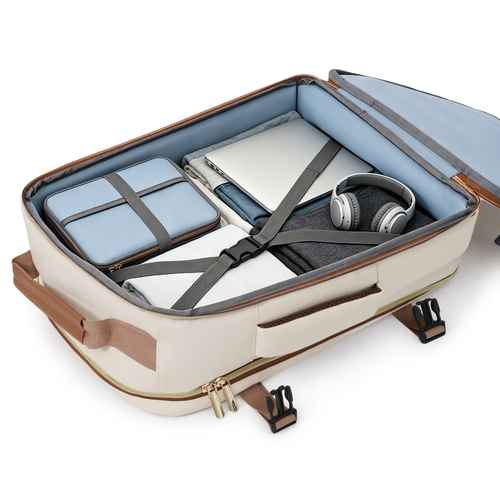 An open beige and brown soft-sided suitcase or travel organizer shown from above, filled with travel accessories including a light blue organizer pouch, a white tablet case, gray headphones, and a dark gray compression pillow, on a white background.