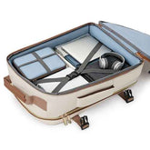 An open beige and brown soft-sided suitcase or travel organizer shown from above, filled with travel accessories including a light blue organizer pouch, a white tablet case, gray headphones, and a dark gray compression pillow, on a white background.