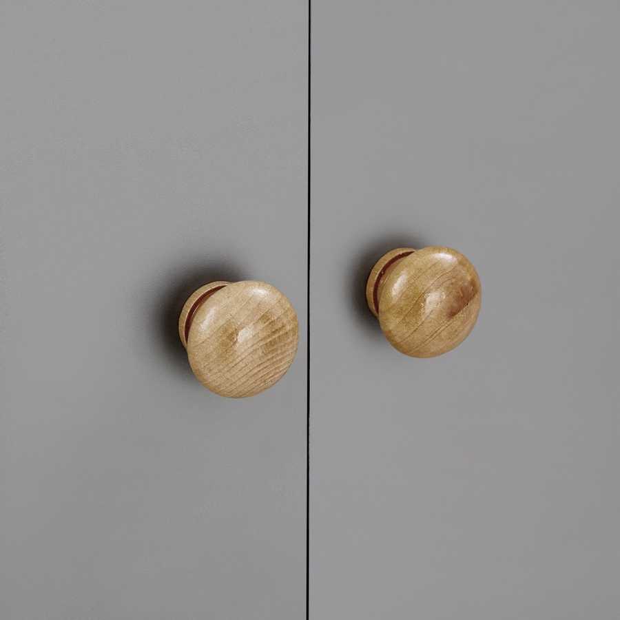 Detail view of the wooden knobs on the gray cabinet doors of the multi-functional shoe storage bench, showing craftsmanship.