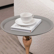 Close-up of Mermaid Tail Coffee Table top with a white cup and book, showcasing the smooth grey surface and functional design.
