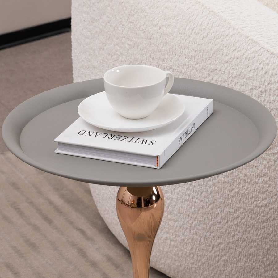 Close-up of Mermaid Tail Coffee Table top with a white cup and book, showcasing the smooth grey surface and functional design.
