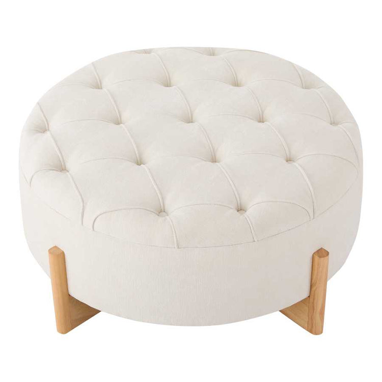 Round ottoman with tufted white cushion and wooden legs on a white background
