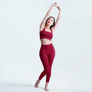 Woman in red athletic wear posing against a light gray background