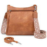 Brown leather handbag with patterned strap on a white background