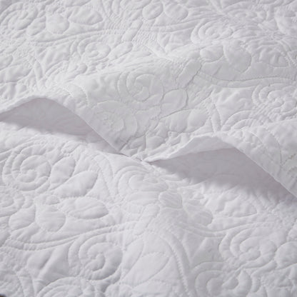 Close-up of white oversized quilted throw 60x70 showing detailed floral stitching on soft cotton fabric for elegant bedding.