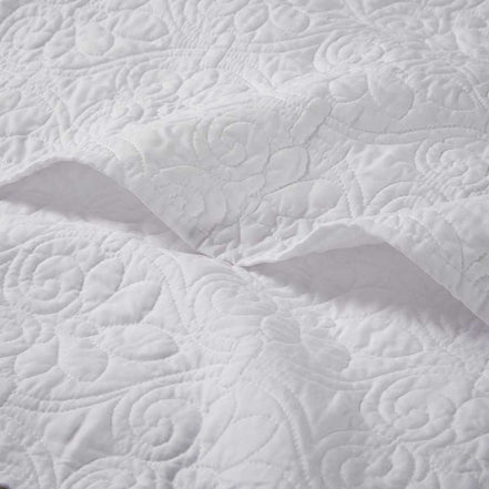 Close-up of white oversized quilted throw 60x70 showing detailed floral stitching on soft cotton fabric for elegant bedding.