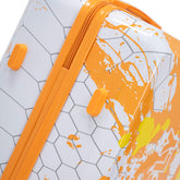 Close-up of a suitcase with orange and white abstract design on a geometric patterned background