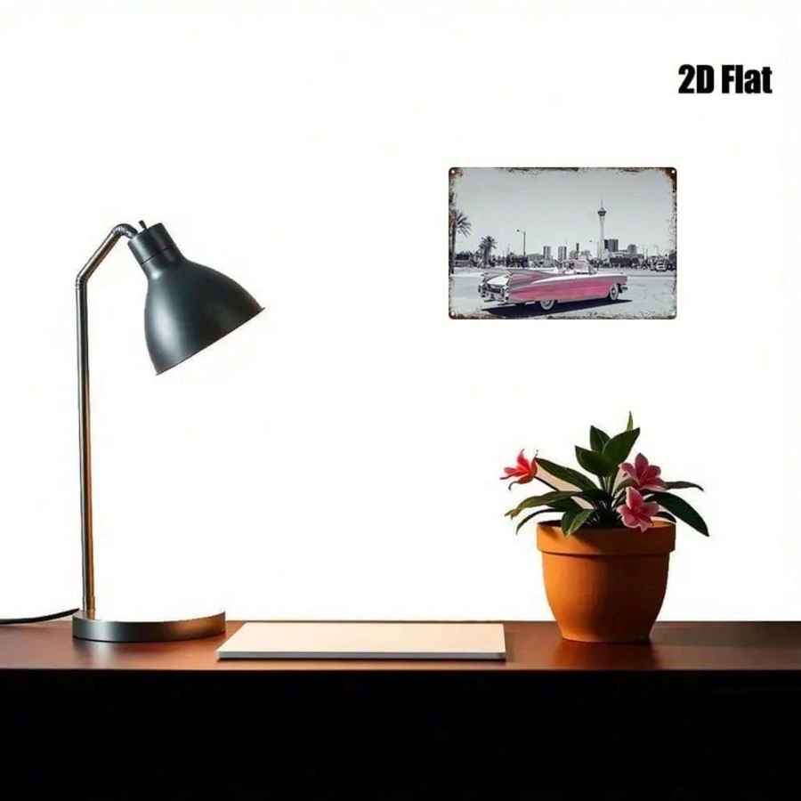 A rectangular vintage-style wall art print with a distressed metal look hangs on a white wall above a desk. The print shows a black-and-white city street scene with a pink car.