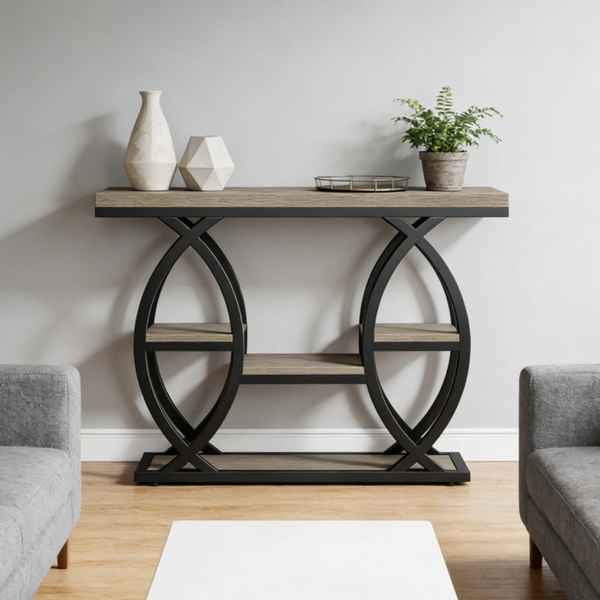 A console table with a rustic light brown wood top and shelves, supported by a black metal frame with interlocking circular arches, styled in a living room setting.