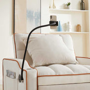 Close-up of phone holder attached to convertible beige velvet sofa bed with USB port. Perfect for hands-free device use in small spaces.