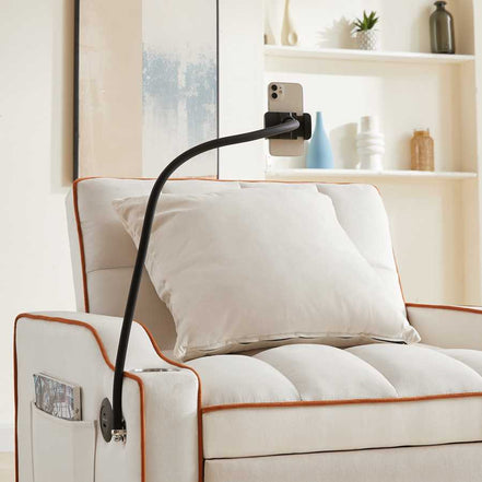 Close-up of phone holder attached to convertible beige velvet sofa bed with USB port. Perfect for hands-free device use in small spaces.