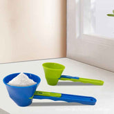 Blue and green measuring cups with a funnel on a white surface.