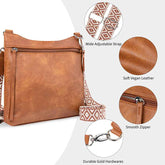 Brown leather handbag with wide adjustable strap, soft vegan leather, smooth zipper, and durable gold hardware on a white background.